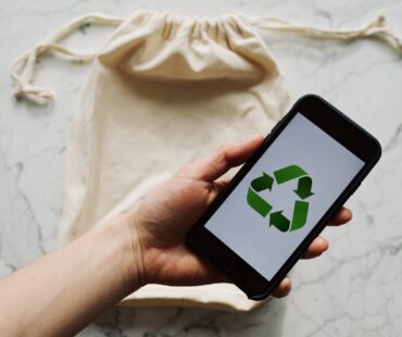 Free Faceless person showing recycle symbol on mobile phone screen Stock Photo