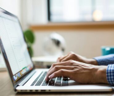 person typing on silver Macbook
