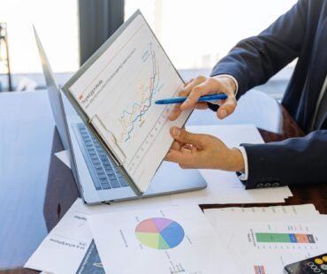Free Business professionals discussing financial graphs and charts in an office setting. Stock Photo
