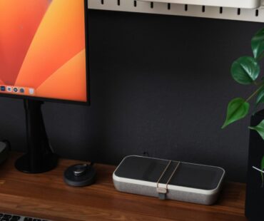 a desk with a laptop, keyboard, mouse and a monitor