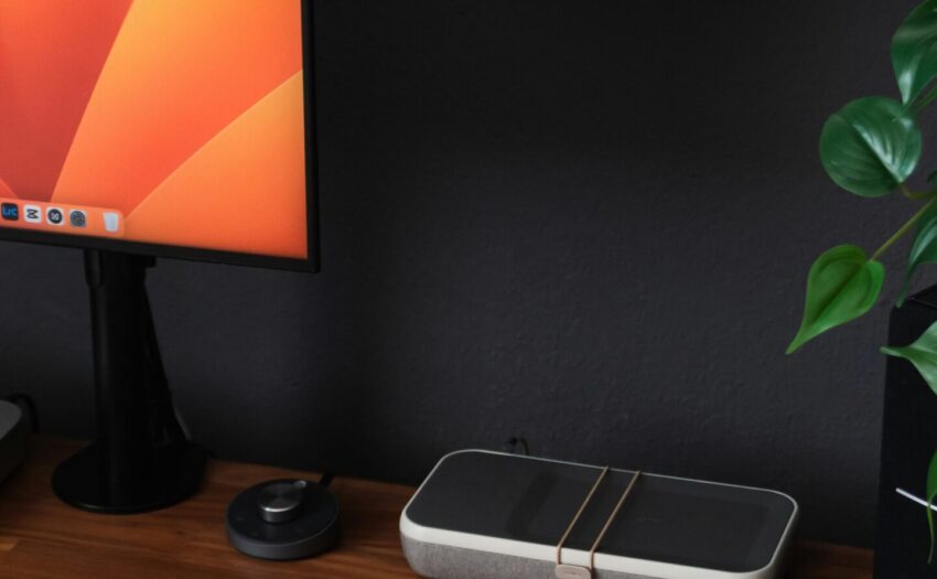 a desk with a laptop, keyboard, mouse and a monitor