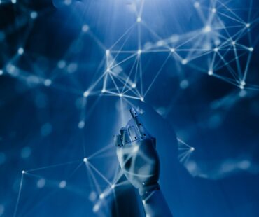 Free A robotic hand reaching into a digital network on a blue background, symbolizing AI technology. Stock Photo