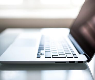 Free Elegant side view of a laptop on a glossy table with natural lighting indoors. Stock Photo